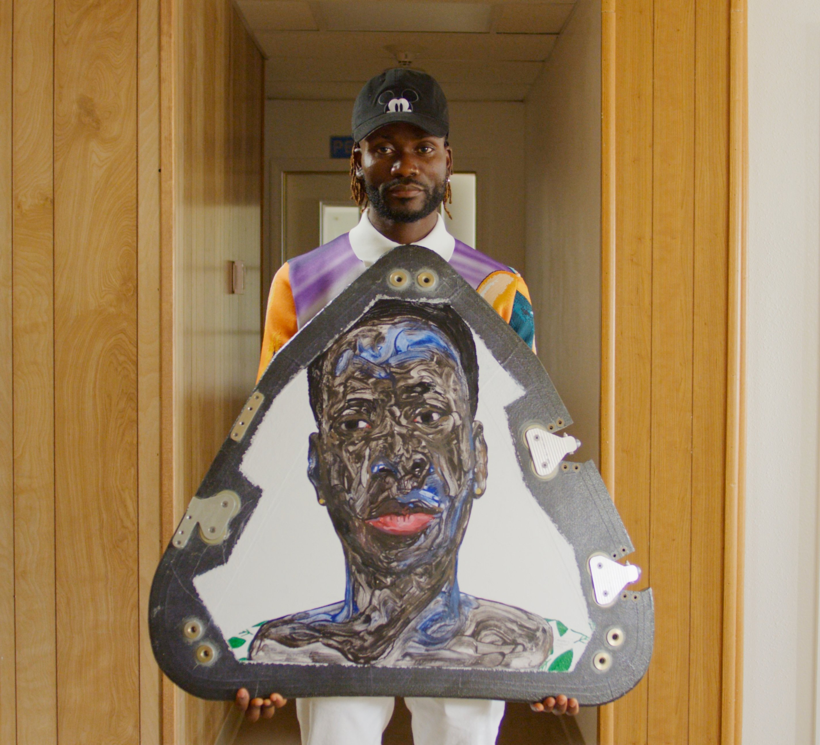 Amoako Boafo with his painting Shormeh’s Gold Earrings (2021) from the "Suborbital Triptych," which flew to space with Blue Origin. Photo courtesy of Uplift Aerospace.