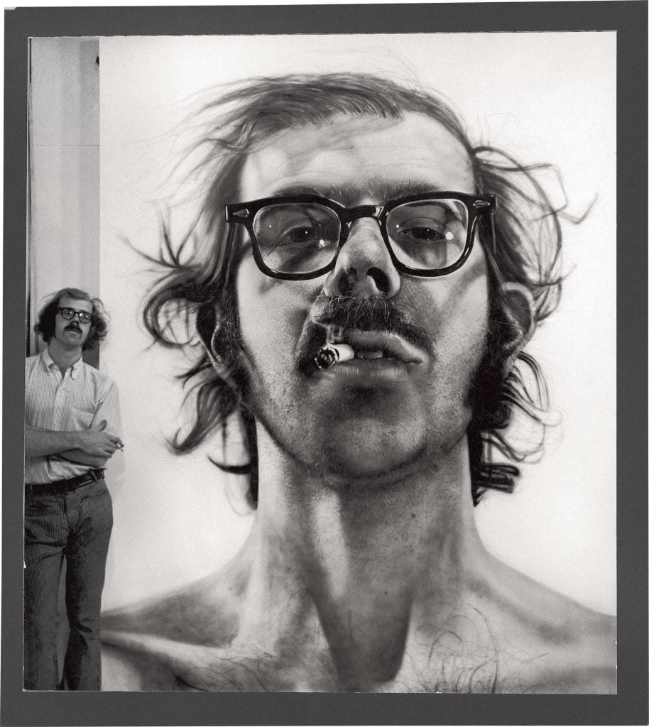 Chuck Close with his <em>Big Self-Portrait</em>, (1967–68), photographed in his studio in 1968. Photo by Kenny Lester ©Chuck Close/courtesy of Pace Gallery.