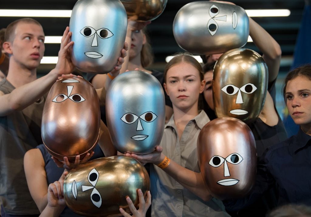 Students dance to the opening of the Bauhaus Museum Dessau with stage masks, which go back to Oskar Schlemmer and the Bauhaus. Photo by Hendrik Schmidt/picture alliance via Getty Images.