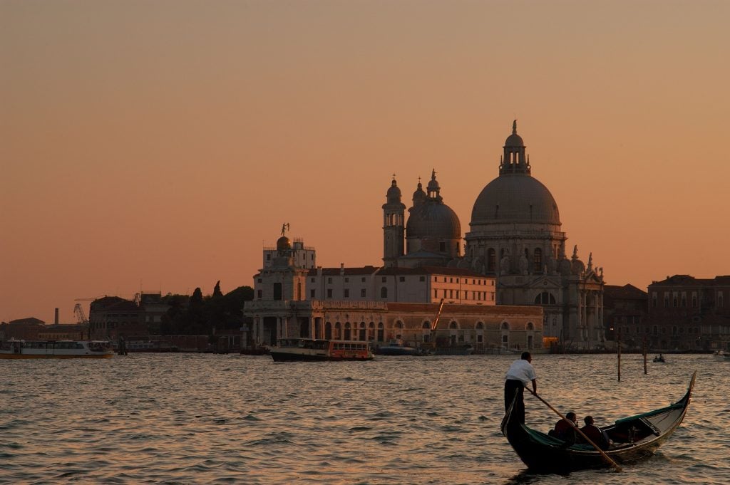Venice's Basilica of San Maria de Salute and a gondolier at sunset. Photo by Michel Baret/Gamma-Rapho via Getty Images.