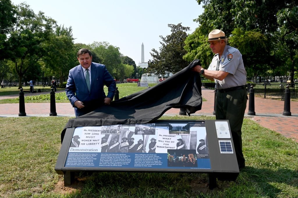 Stewart McLaurin, president of the White House Historical Association and John Stanwich with the National Park Service unveil one of three plaques in Lafayette Square Park that note contributions of enslaved people to the building of the White House, the location of the park as a protest zone and describes Jackie Kennedy's contributions to creating the White House Historical Association July 28, 2021 in Washington, DC. Photo by Katherine Frey/The Washington Post via Getty Images.