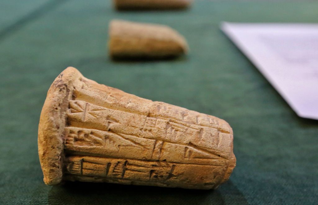 Mesopotamian clay cones bearing cuneiform inscriptions are displayed during a handover ceremony of a trove of looted Iraqi antiquities returned by the United States, at the Ministry of foreign Affairs in the capital Baghdad, on August 3, 2021. Photo by SABAH ARAR/AFP via Getty Images.