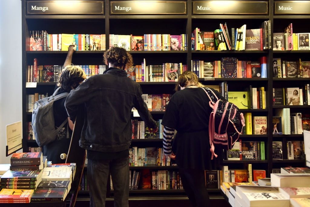 Teenagers browse the books under the Manga section at book shop. (Photo by John Keeble/Getty Images)