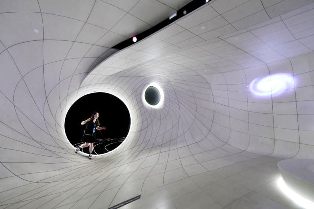 A visitor experiences walking on the simulated black hole at the Shanghai Astronomy Museum on its opening day on July 17, 2021 in Shanghai, China. Photo by Yang Jianzheng/VCG via Getty Images.
