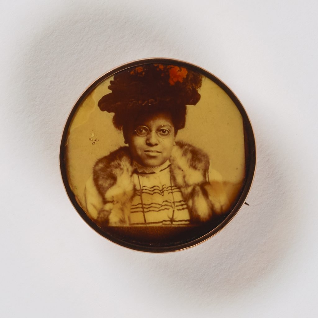 Unidentified artist, <i>Untitled (pin, woman in hat)</i>, undated, celluloid in metal setting. Courtesy of the Smithsonian American Art Museum.