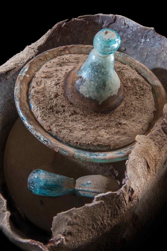 A blue glass urn found in the tomb of Marcus Venerius Secundio next to a marker reading "Novia Amabilis." Photo courtesy of the Archaeological Park of Pompeii/University of Valencia.