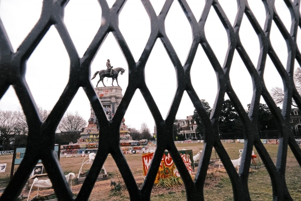 An 8-foot fence is erected around the Robert E. Lee monument on January 25, 2021 in Richmond to prepare the site for the removal of the statue. Photo: Eze Amos/Getty Images.