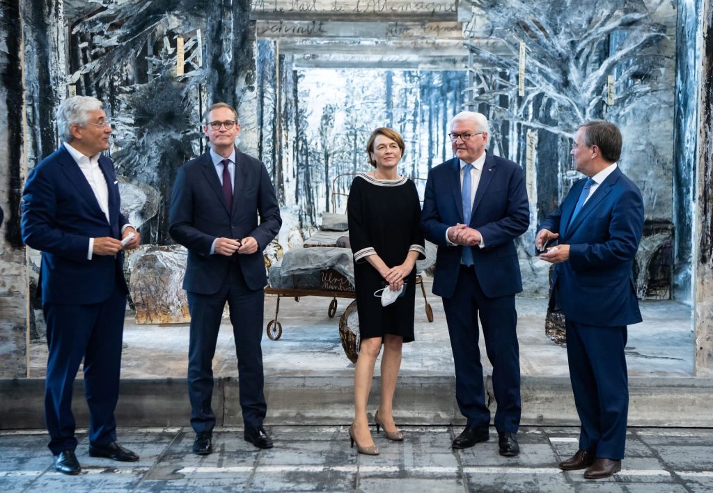 Federal President Frank-Walter Steinmeier and his wife Elke Büdenbender are guided through the exhibition "Diversity United" by Walter Smerling (left), Berlin mayor Michael Müller (2nd from left), and Armin Laschet (right) chancelor candidate and minister President of North Rhine-Westphalia stand in front of a work by Anselm Kiefer. Photo by Bernd von Jutrczenka/picture alliance via Getty Images.