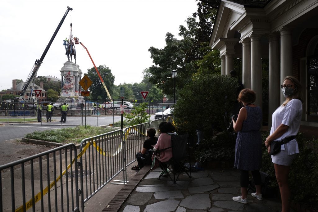 People watch the removal of the statue of Robert E. Lee at Robert E. Lee Memorial September 8, 2021 in Richmond, Virginia. Photo : Alex Wong/Getty Images.