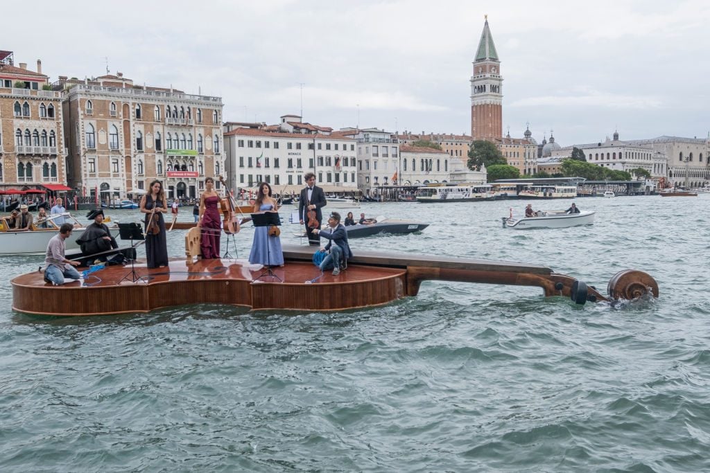 The violin shaped boat is towed into the yard at the end of the parade on September 18, 2021 in Venice, Italy. Photo by Stefano Mazzola/Awakening/Getty Images.
