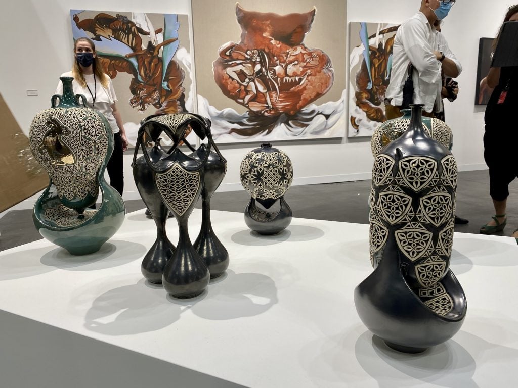 Sculptures by Ibrahim Said and paintings by Asif Tanvir Hoque at Yossi Milo Gallery, New York, at the 2021 Armory Show at the Javits Center in New York. Photo by Sarah Cascone. 