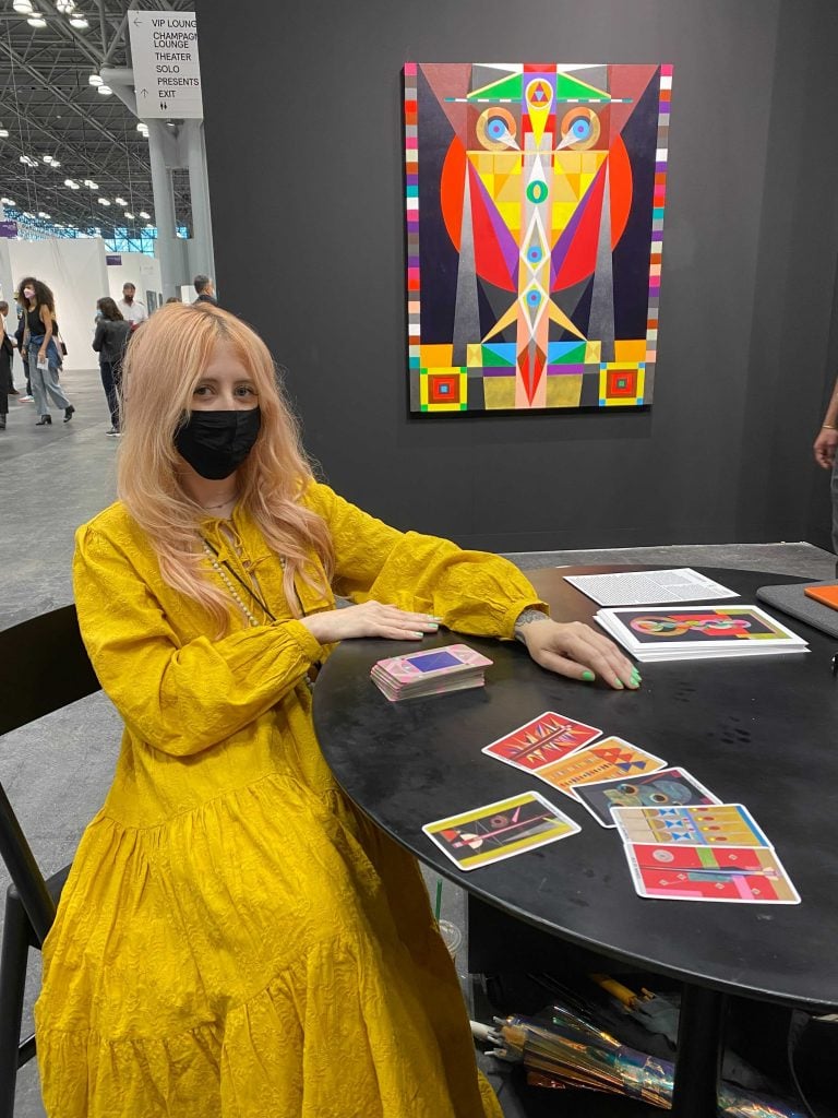 Sarah Potter giving a tarot card reading with Hilma's Ghost's "Abstract Futures Tarot" deck at the booth of Chicago's Carrie Secrist Gallery at the Armory Show in New York. Photo by Sarah Cascone. 