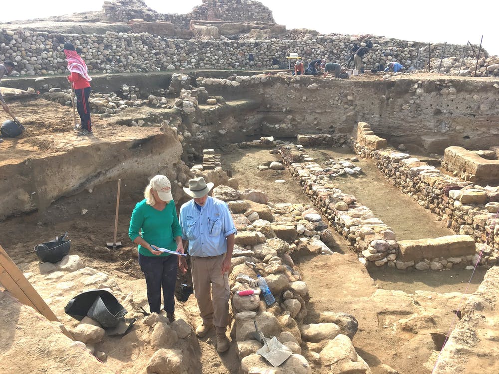 Researchers stand near the ruins of Tall el-Hammam's ancient walls, with the destruction layer about midway down each exposed wall. Photo by Phil Silvia, Creative Commons Attribution-NoDerivs 4.0 Generic license.
