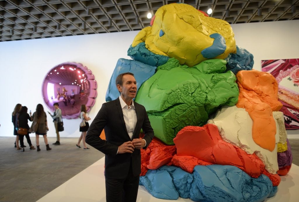 Artist Jeff Koons poses next to his sculpture titled Play-Doh during a press preview of 