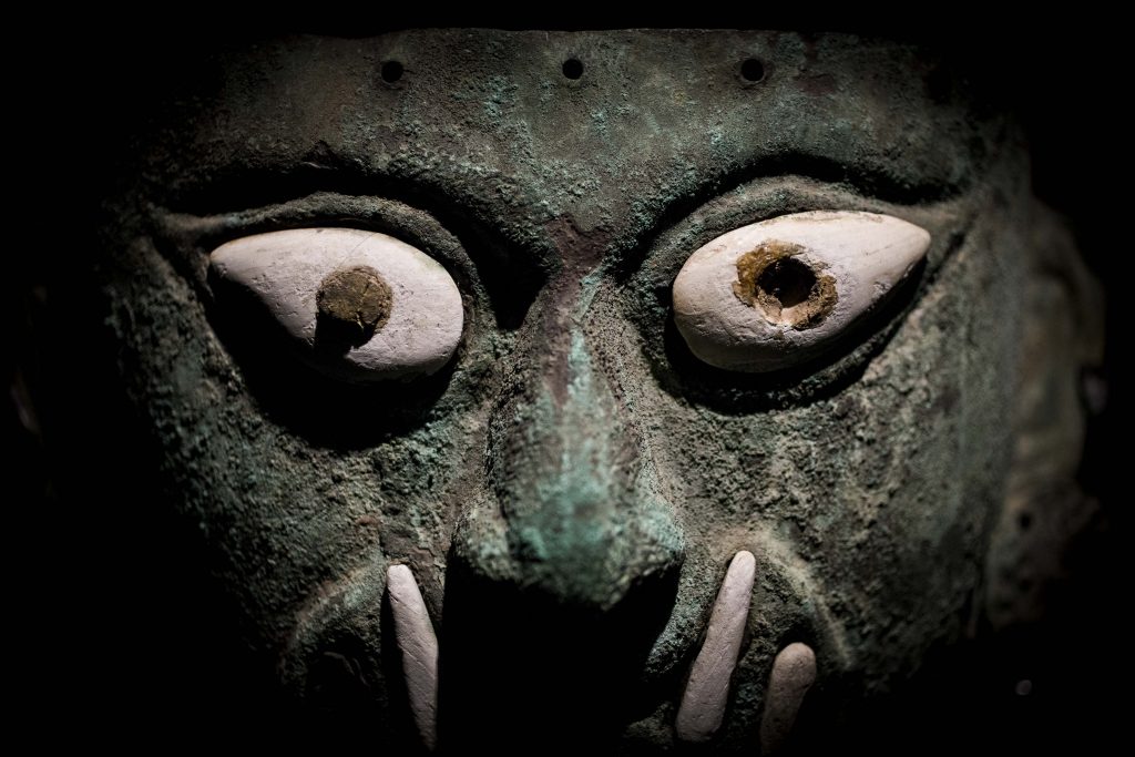 Ai Apaec, copper funerary mask with applications of shell and stone, depicting an anthropomorphic visage with feline fangs (ca. 1 AD –800 AD). Collection of the Museo Larco, Lima, Peru. Photo courtesy of World Heritage Exhibitions.