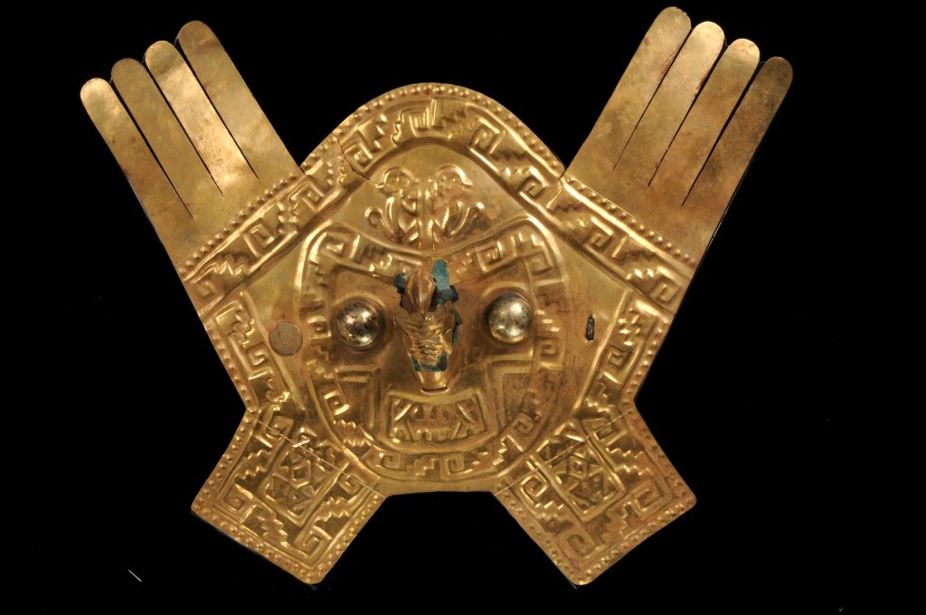 Frontal adornment of gold headdress depicting feline head with feathers, bird-beak nose, and figure with headdress of plumes and triangular pendants, depiction of two animals (monkeys) on the upper part, stepped designs with volutes and two-headed- serpent designs on the lower part (ca. 1300 AD-1532 AD). Collection of the Museo Larco, Lima, Peru. Photo courtesy of World Heritage Exhibitions.