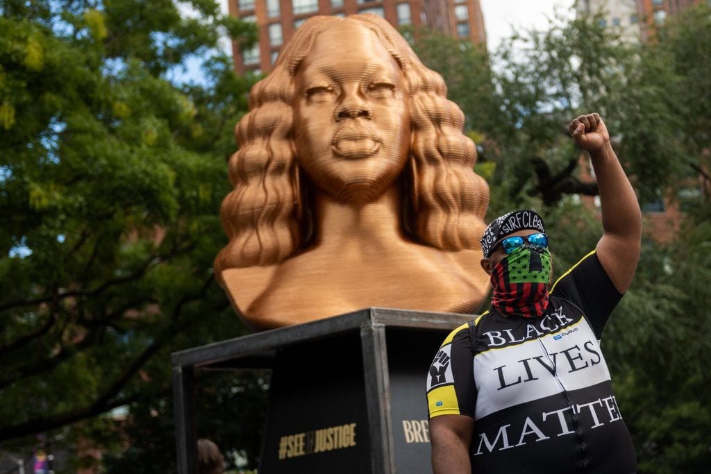 Chris Carnabuci, <em>BREONNA</em> in Confront Art's exhibition "Seeinjustice" in Union Square in New York City. Jason Woody of California poses with the monument. Photo by Alexi Rosenfeld/Getty Images.