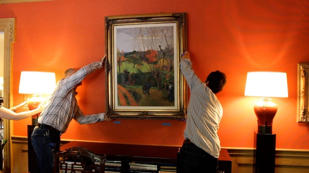 The Nelson Atkins staff hanging a reproduction on a wall in Bloch's home. Photo: Laura Holthus.