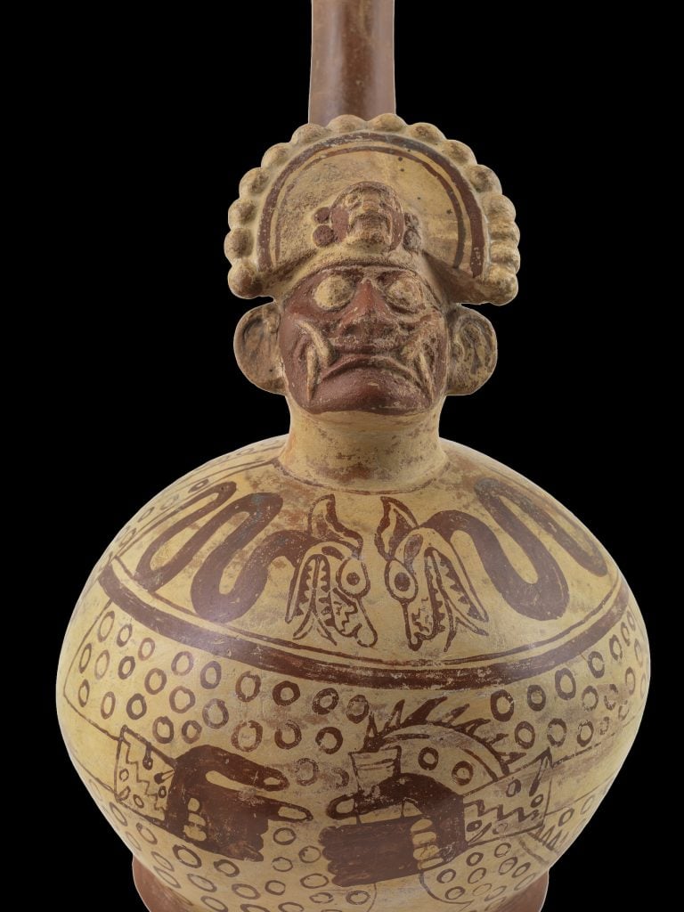 Sculptural stirrup spout bottle depicting an anthropomorphic figure with supernatural traits (hero Ai Apaec) holding a knife or tumi (1 AD–800 AD). Collection of the Museo Larco, Lima, Peru. Photo courtesy of World Heritage Exhibitions.