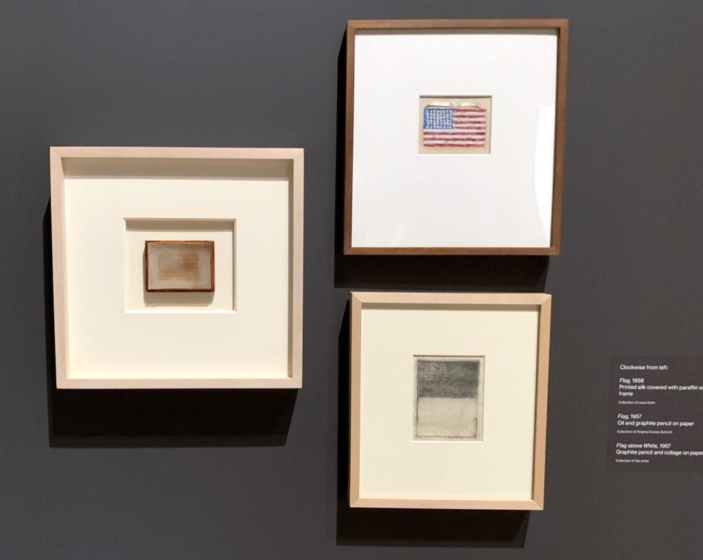 Jasper Johns, <em>Flag</em> (1958), <em>Flag</em> (1957), and <em>Flag Above White</em> (1957) in the "Small" gallery at the Whitney. Photo by Ben Davis.