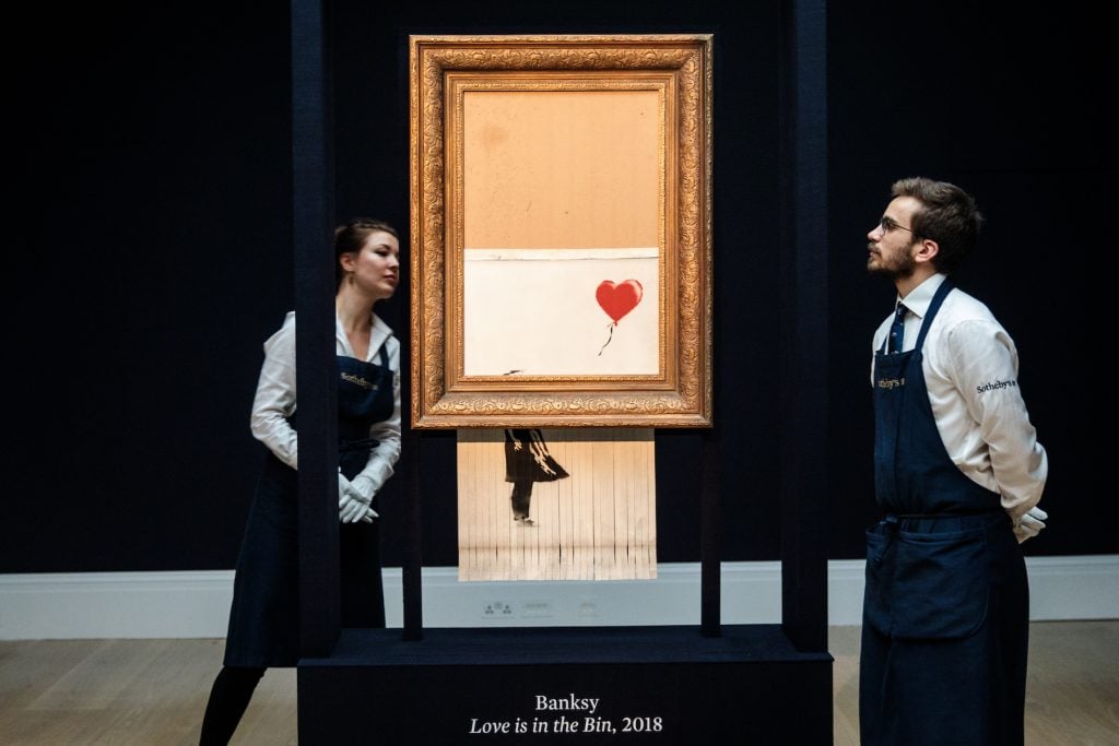 Sotheby's employees view Love is in the Bin by British artist Banksy during a media preview at Sotheby's auction house on October 12, 2018 in London, United Kingdom.(Photo by Jack Taylor/Getty Images)