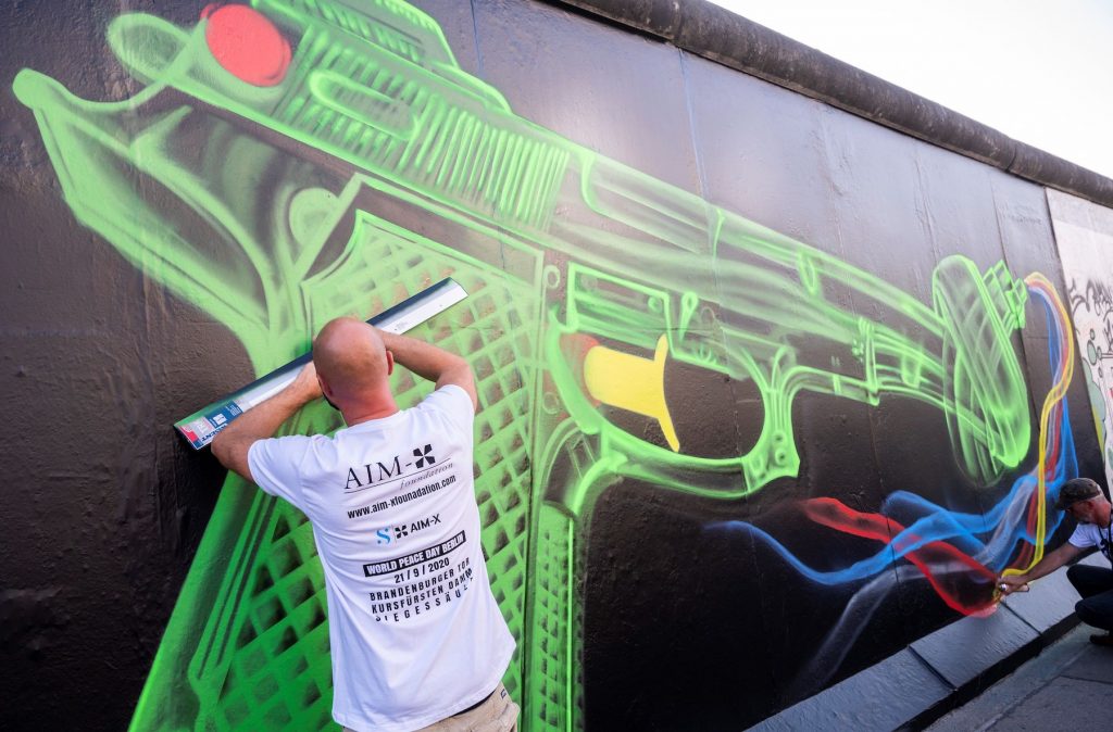 Street artists create a mural in Berlin on September 22, 2020. (Photo by John MacDouglall/AFP via Getty Images)