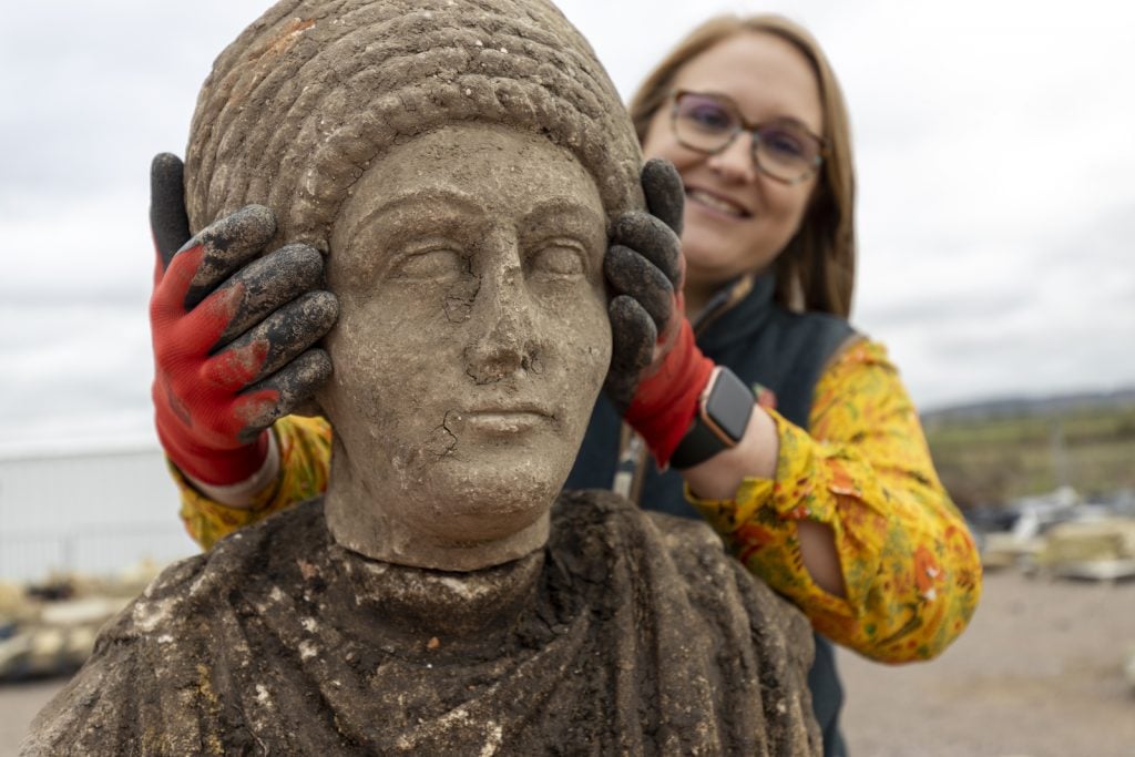 Dr. Rachel Wood with one of the adult Roman busts discovered at the St Mary's Archaeological dig in Stoke Mandeville, Buckinghamshire. Courtesy of HS2.