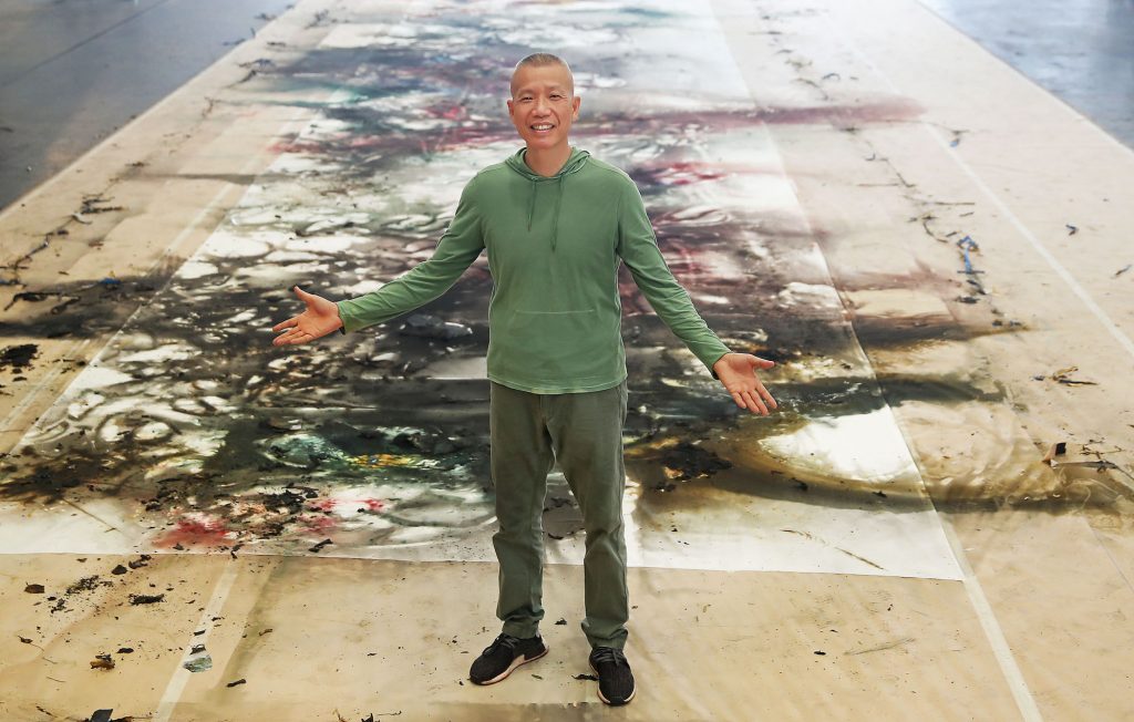 Contemporary artist Cai Guo-Qiang poses after creating a new work from fire and gunpowder;  31-meter gunpowder on a silk drawing, titled Transience II (Peony) (2019).  Photograph by Scott Barbour / Getty Images for NGV.