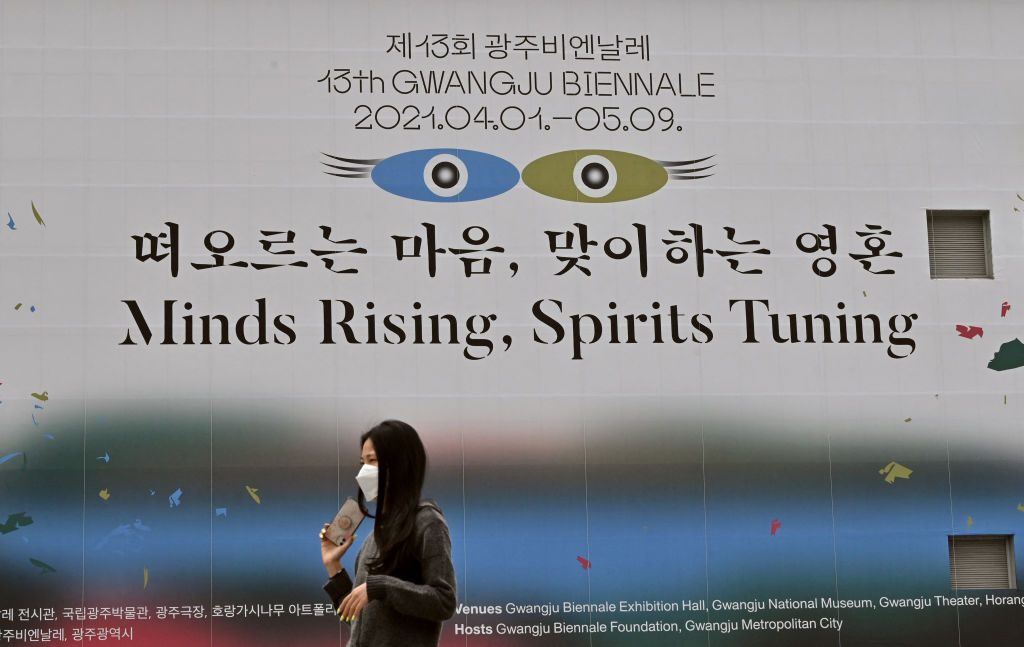 A visitor walks past a poster for the 13th Gwangju Biennale at an exhibition hall in the city of Gwangju on April 1, 2021. Photo: Jung Yeon-je / AFP via Getty Images.