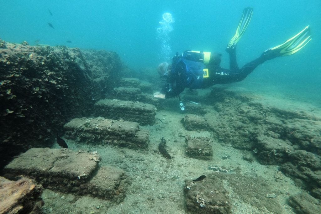 Divers at the Villa a Protiro, in the submerged ancient Roman city of Baia at the Underwater Archaeological Park of Baia, part of the Campi Flegrei Archaeological Park complex site in Pozzuoli near Naples. Photo by Andreas Solaro/AFP via Getty Images.