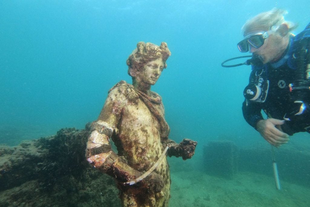 A copy of an original statue, preserved at the Museum of Baiae, of Dionysus, in the submerged ancient Roman city of Baia at the Underwater Archaeological Park of Baia, part of the Campi Flegrei Archaeological Park complex site in Pozzuoli near Naples. Photo by Andreas Solaro/AFP via Getty Images.