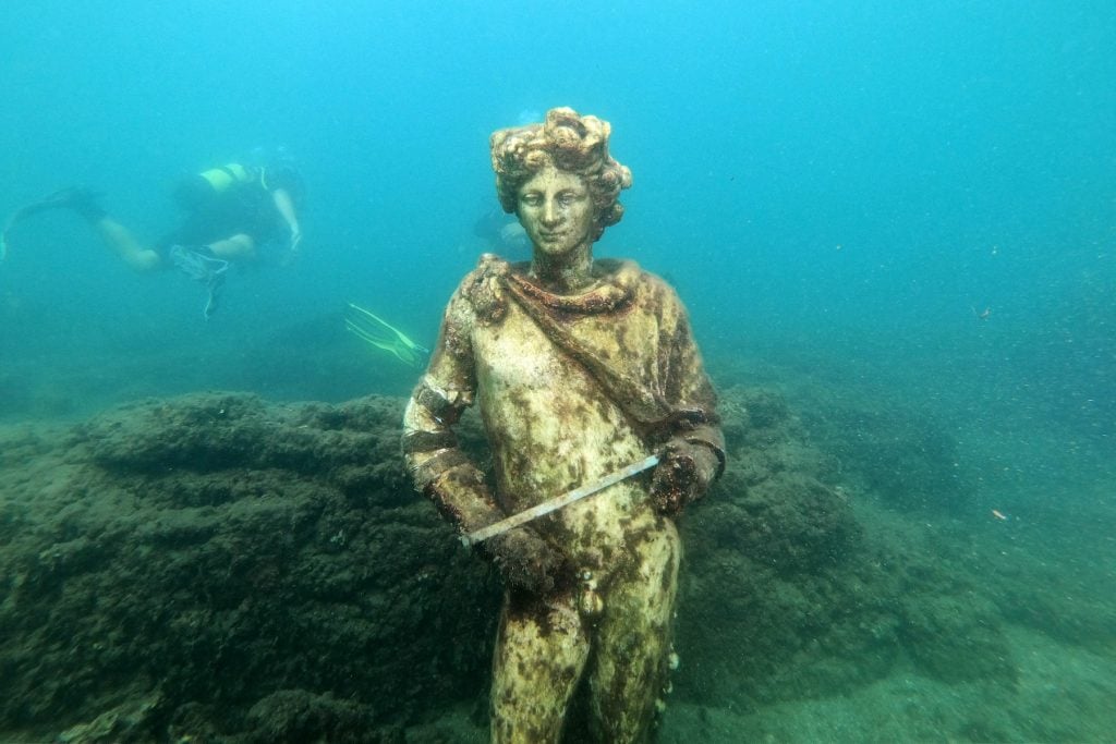 A copy of an original statue, preserved at the Museum of Baiae, of Dionysus, in the submerged ancient Roman city of Baia at the Underwater Archaeological Park of Baia, part of the Campi Flegrei Archaeological Park complex site in Pozzuoli near Naples. Photo by Andreas Solaro/AFP via Getty Images.
