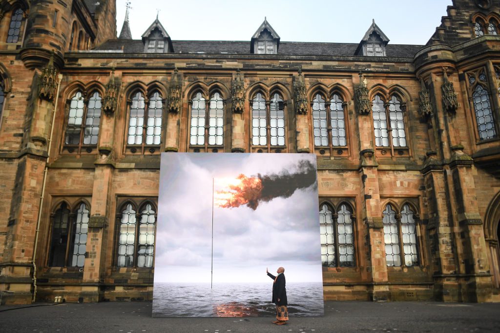 Tongan artist and climate activist, Uili Lousi is seen with John Gerrard's Flare Oceania (2021) on November 5 in Glasgow, on the occasion of COP26. Photo: Peter Summers/Getty Images.
