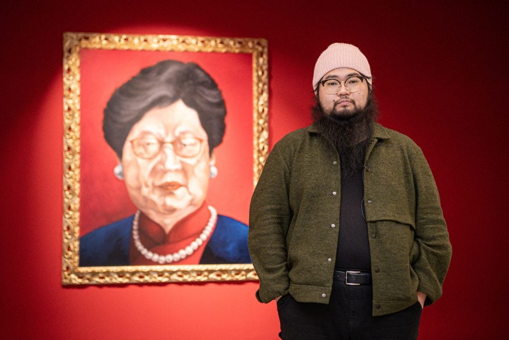 Chinese dissident artist Badiucao with his painting Carrie Lam (2018) at the Santa Giulia museum in Brescia, Lombardy. Photo by Piero Cruciatti/AFP via Getty Images.