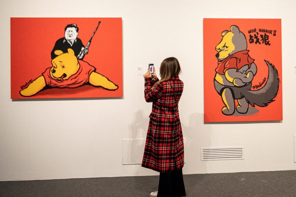 A visitor takes photos of "Winnie the Trophies, 2017", an artwork by Chinese dissident artist Badiucao at the Santa Giulia museum in Brescia, Lombardy. Photo by Piero Cruciatti/AFP via Getty Images.