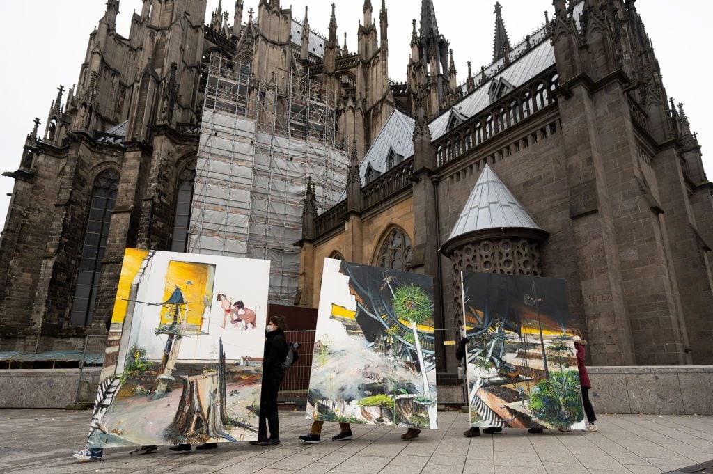 Climate activists carry the painting "Das Grosse Gelingen" from 2021 by the artist couple Helge & Saxana through Cologne towards Art Cologne. The action is intended to demonstrate against the demolition of the village of Lützerath, which is threatened by the Garzweiler open-cast lignite mine. Photo by Federico Gambarini/picture alliance via Getty Images.