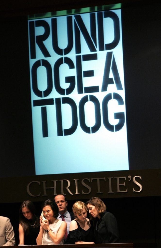 Christopher Wool's <i>Run Dog Eat Dog</i> at Christie's postwar and contemporary art sale in May 2006. Photo: Timothy A. Clary/AFP via Getty Images.