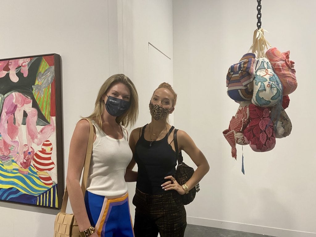 Sarah Arison and Zoe Buckman with the latter's work with London's Pippy Houldsworth Gallery at Art Basel Miami Beach. Photo by Sarah Cascone. 