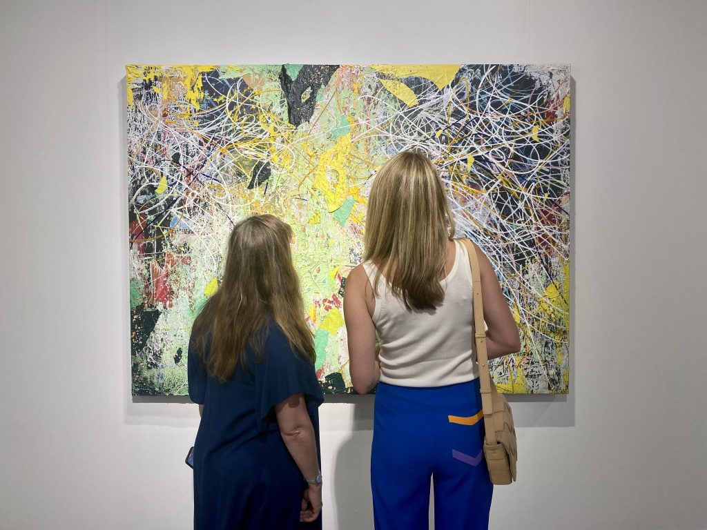Sarah Arison and Kate Fowle admire a painting by Jose Parla from Palm Beach's Ben Brown at Art Basel Miami Beach. Photo by Sarah Cascone. 