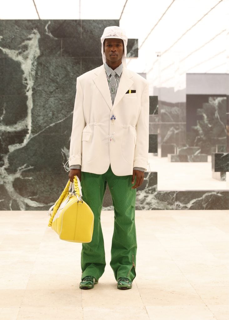 Holding a vintage Monogram Keepall bag with oversized plastic chain strap. © Louis Vuitton – All rights reserved.