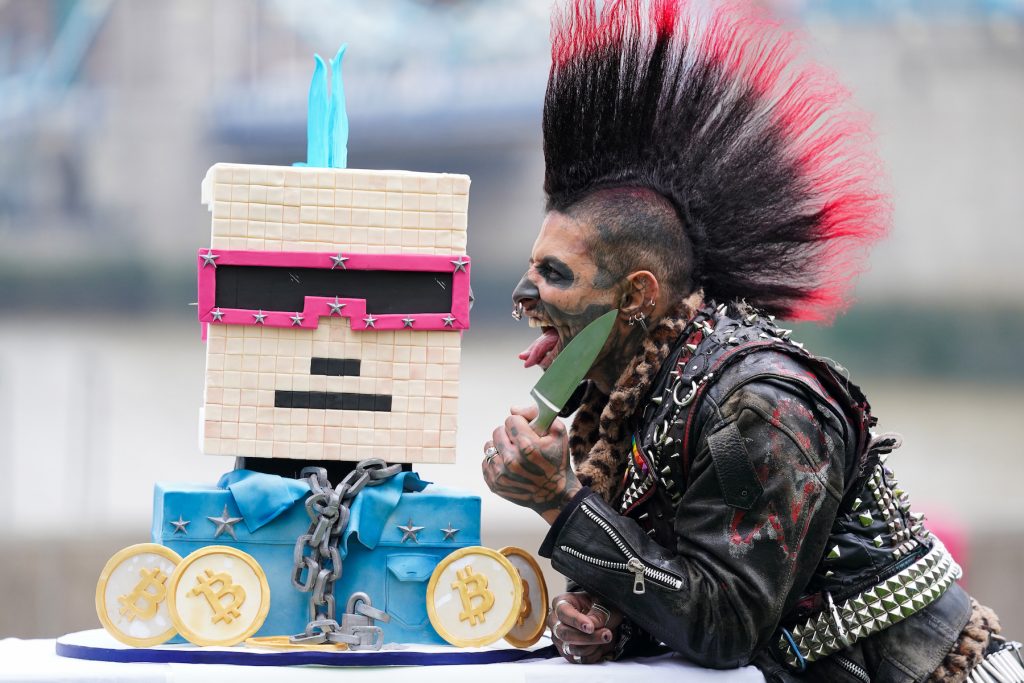 Performer Zombie Punk poses with a NFT CryptoPunk Cake to celebrate the eighth anniversary of crypto exchange, Huobi Global, on November 24, 2021. (Photo by Kirsty O'Connor/PA Images via Getty Images)