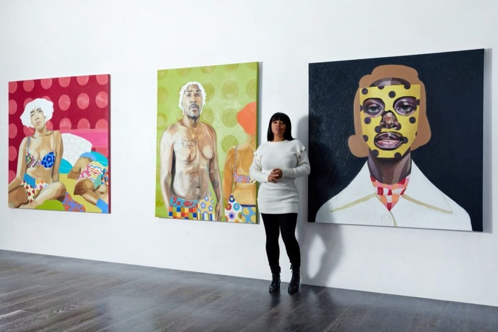 Mashonda Tifrere with, from Lauren Pearce's <em>Just One More Sleep, (2021) and <em>What We Will Remember</em> (2021) and Ronald Jackson's <em>The Magnificent Johnnie Mae King</em> (2021) in “Be of Good Courage” a NYC Culture Club exhibition at Westfield World Trade Center, New York. Photo by Parker Calvert. Courtesy of Mashonda Tifrere and NYC Culture Club.