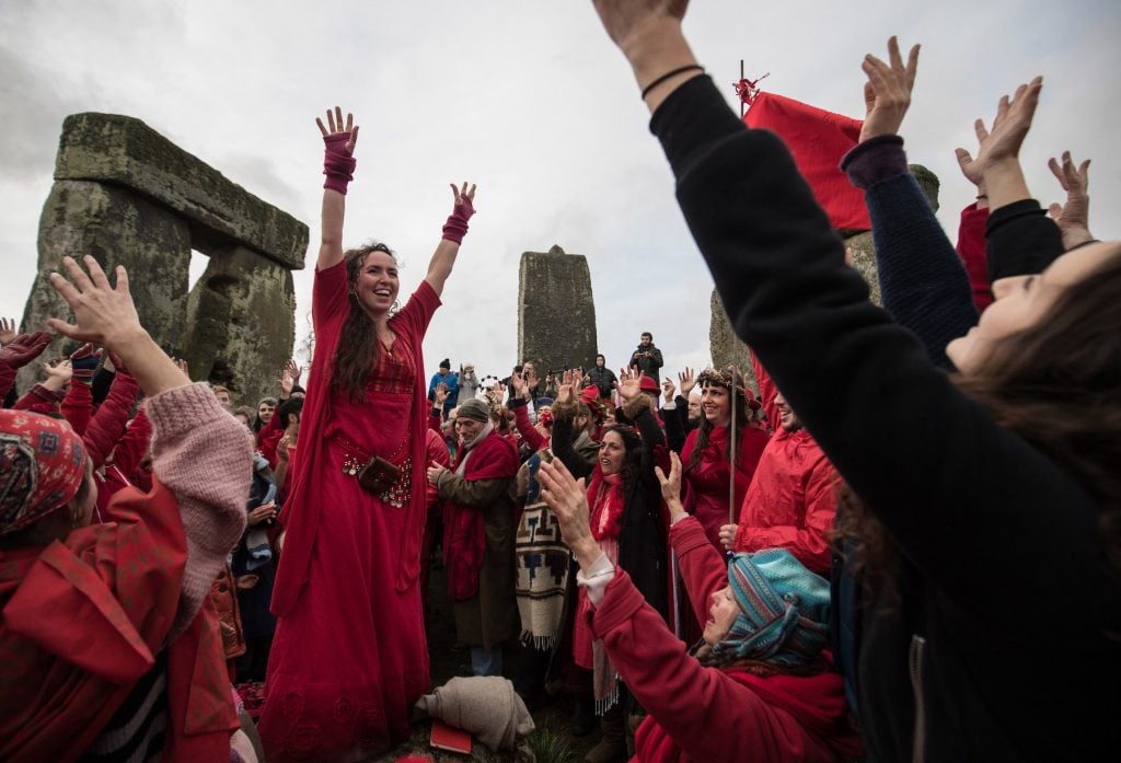 Members of the Shakti Sings choir sing as druids, pagans and revelers take part in a winter solstice ceremony at the ancient neolithic monument of Stonehenge near Amesbury on December 21, 2016 in Wiltshire, England.(Photo by Matt Cardy/Getty Images)