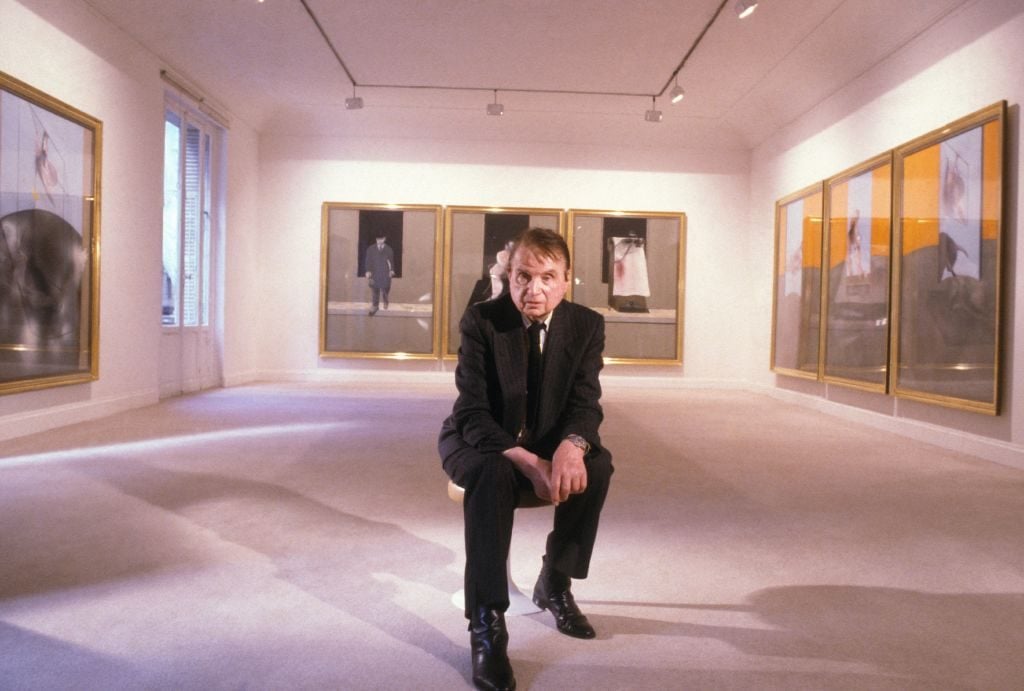 Painter Francis Bacon in front of his paintings in Paris on September 29, 1987. (Photo by Raphael GAILLARDE/Gamma-Rapho via Getty Images)