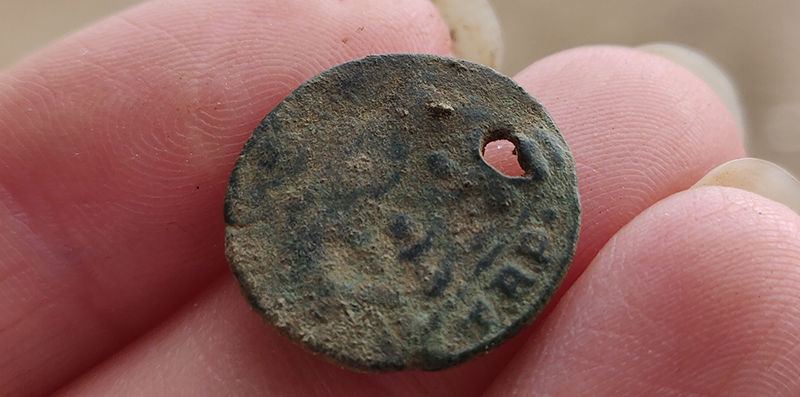 A pierced Roman coin found during excavations at Rendlesham. Photo ⒸSuffolk County Council.