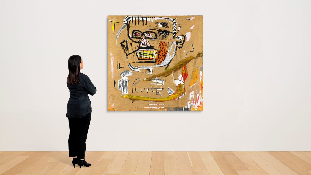 A Christie's employee with Jean-Michel Basquiat's Il Duce (1982). Courtesy of Christie's Images, Ltd.