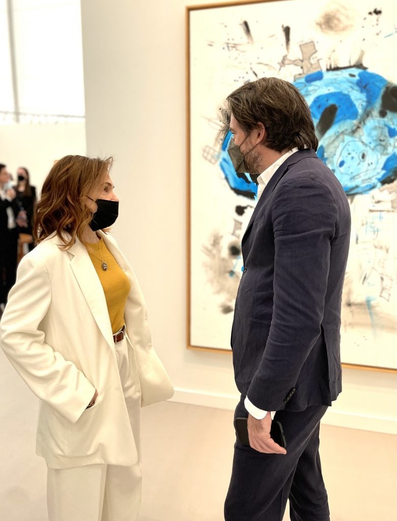Ivy Shapiro and Max Falkenstein in front of a painting by Carroll Dunham.