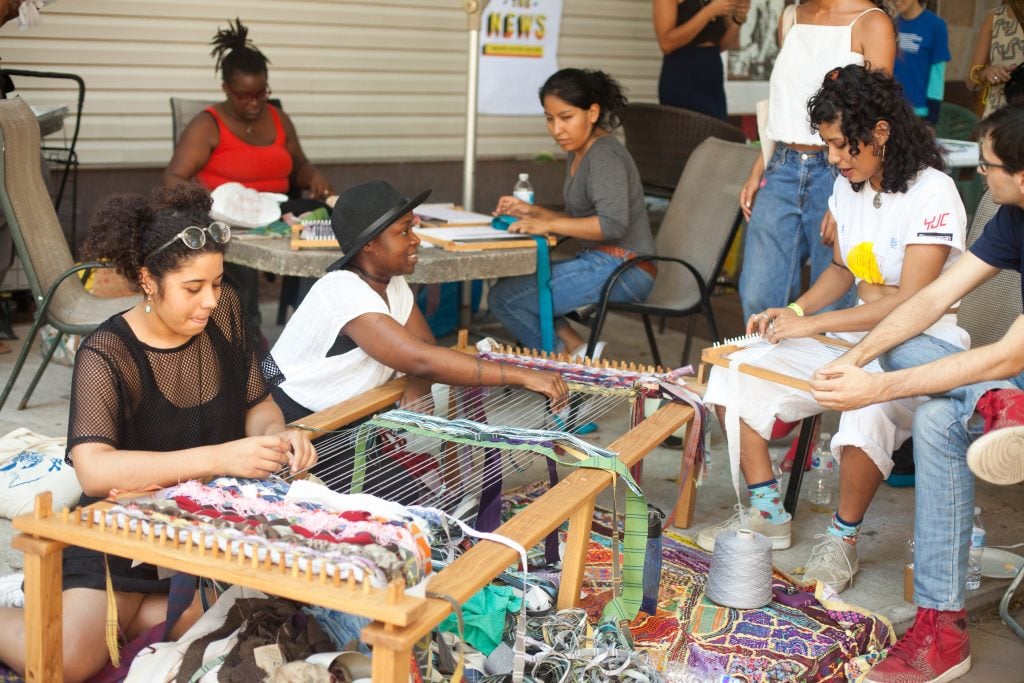 Community members participating in a weaving activity during one of The Laundromat Project's Field Days workshops in 2017. Courtesy of The Laundromat Project. Photo: Neha Gautam.