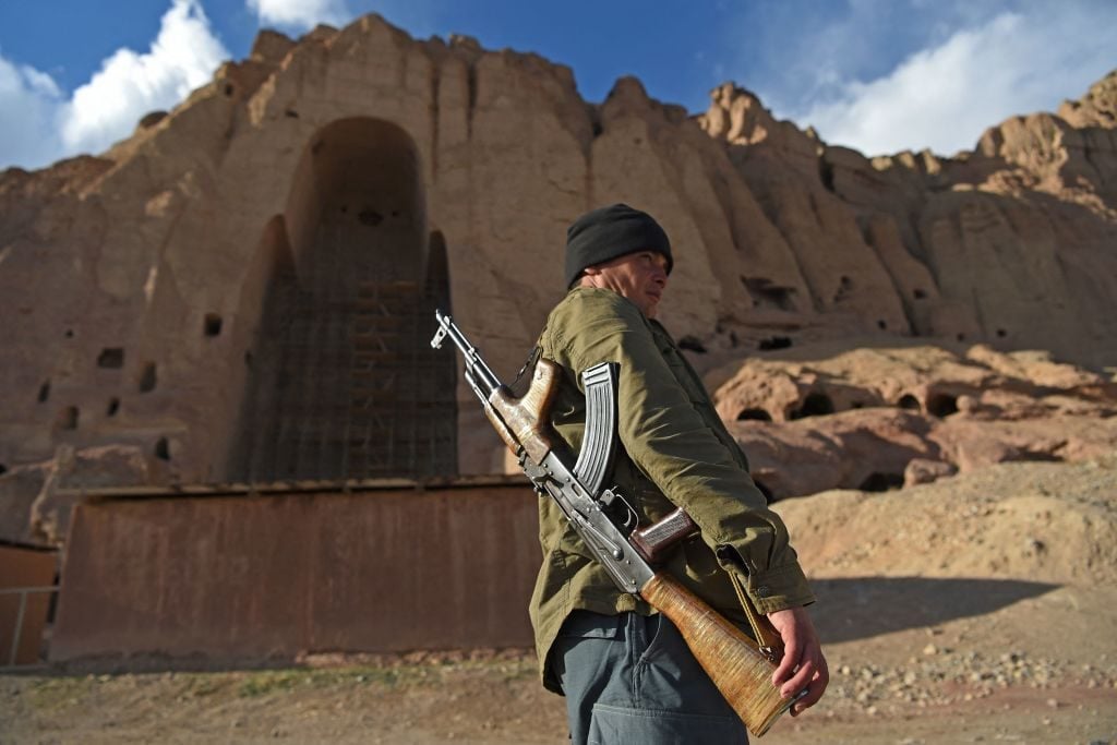 In this picture taken on March 3, 2021 a policeman patrols at the site of the Buddhas of Bamiyan statues, which were destroyed by the Taliban in 2001, in Bamiyan province. Photo by WAKIL KOHSAR/AFP via Getty Images.