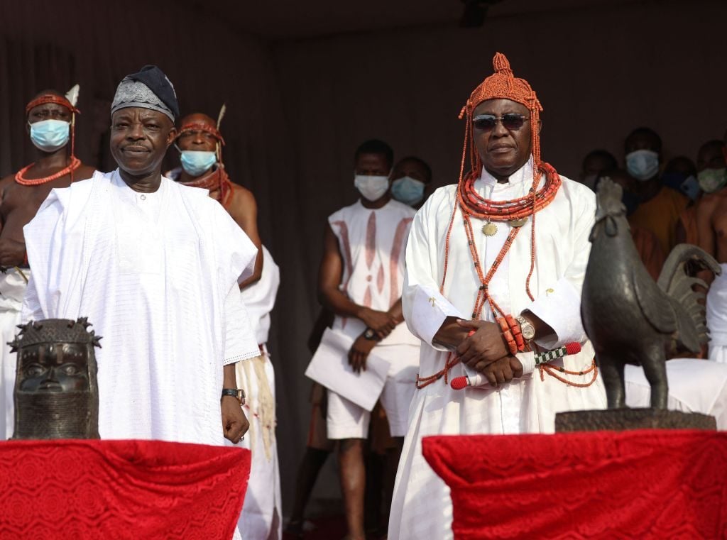 The King, known as Oba of Benin, Omo NOba Uku Akpolokpolo, Ewuare II (R), and Nigeria High Commissioner to the United Kingdom, Sarafadeen Tunji Isola, pose for a photo while receiving repatriated artifacts that were looted from Nigeria over 125 years ago by the British military force in Benin City. Photo: Kola Sulaimon/AFP via Getty Images.